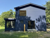 the exterior of a blue house with black siding